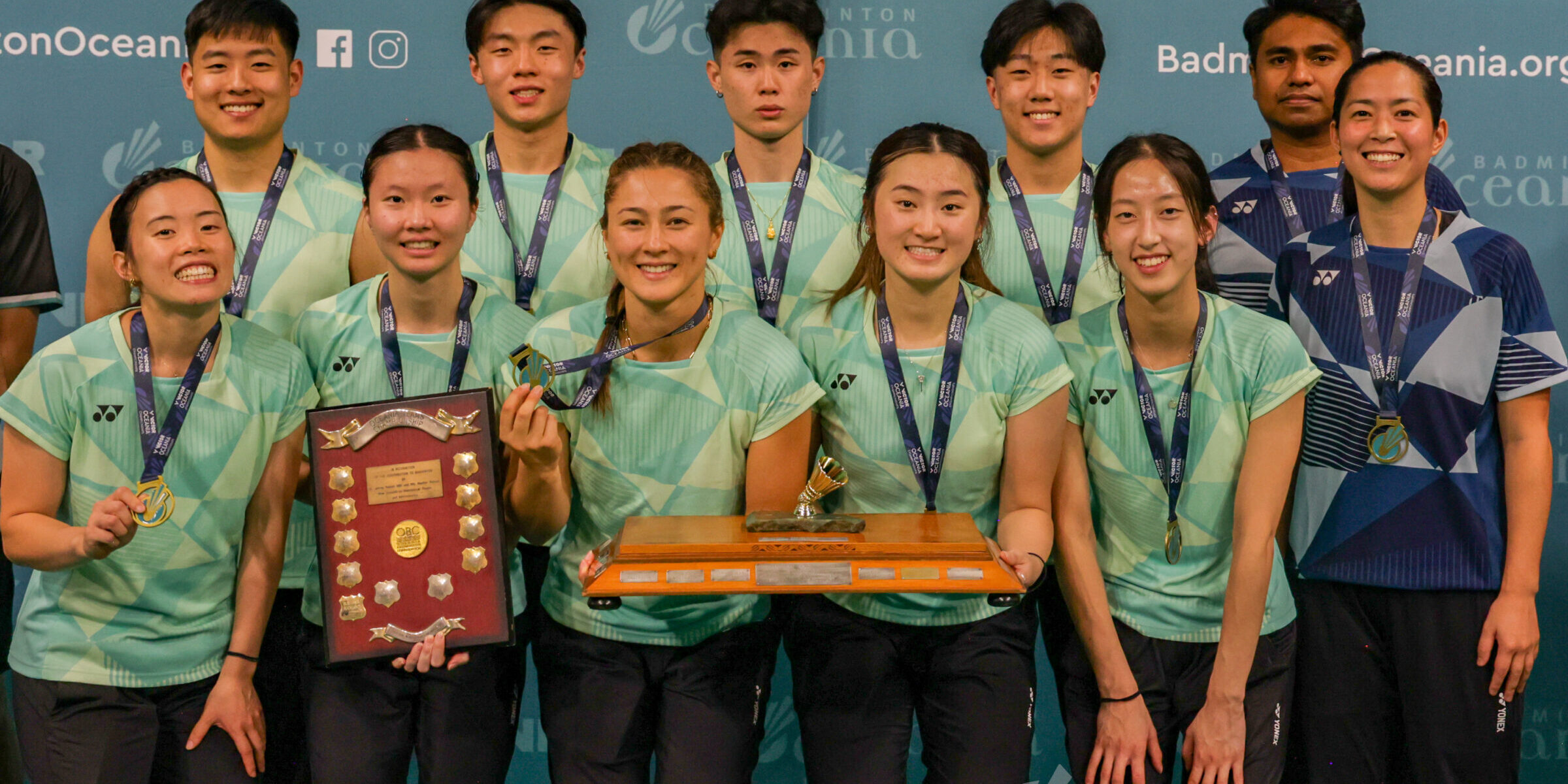 Winners of the VICTOR Oceania Mixed Team Badminton title holding trophy.
