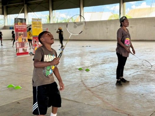 A group of people playing badminton Description automatically generated